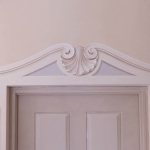 Decorazione di porta con cornice e pannelli a trompe l'oeil